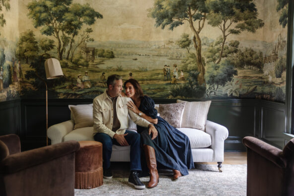 Chris & Julia cozied up on a couch in the moody green study