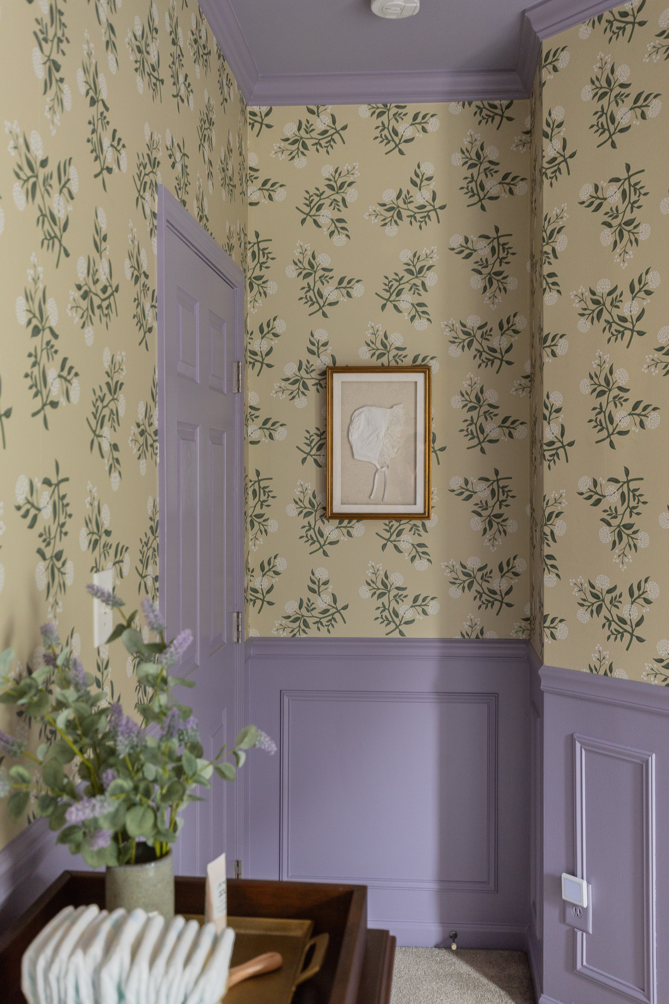 Elegant nursery room wall with floral wallpaper.
