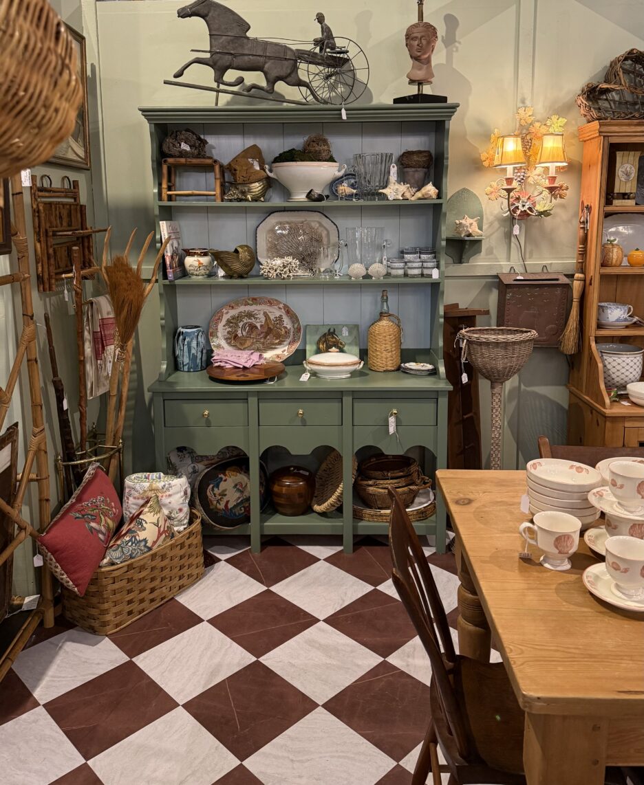 Charming vintage hutch displaying decorative ceramics, collectibles, and antique items in a cozy shop setting.