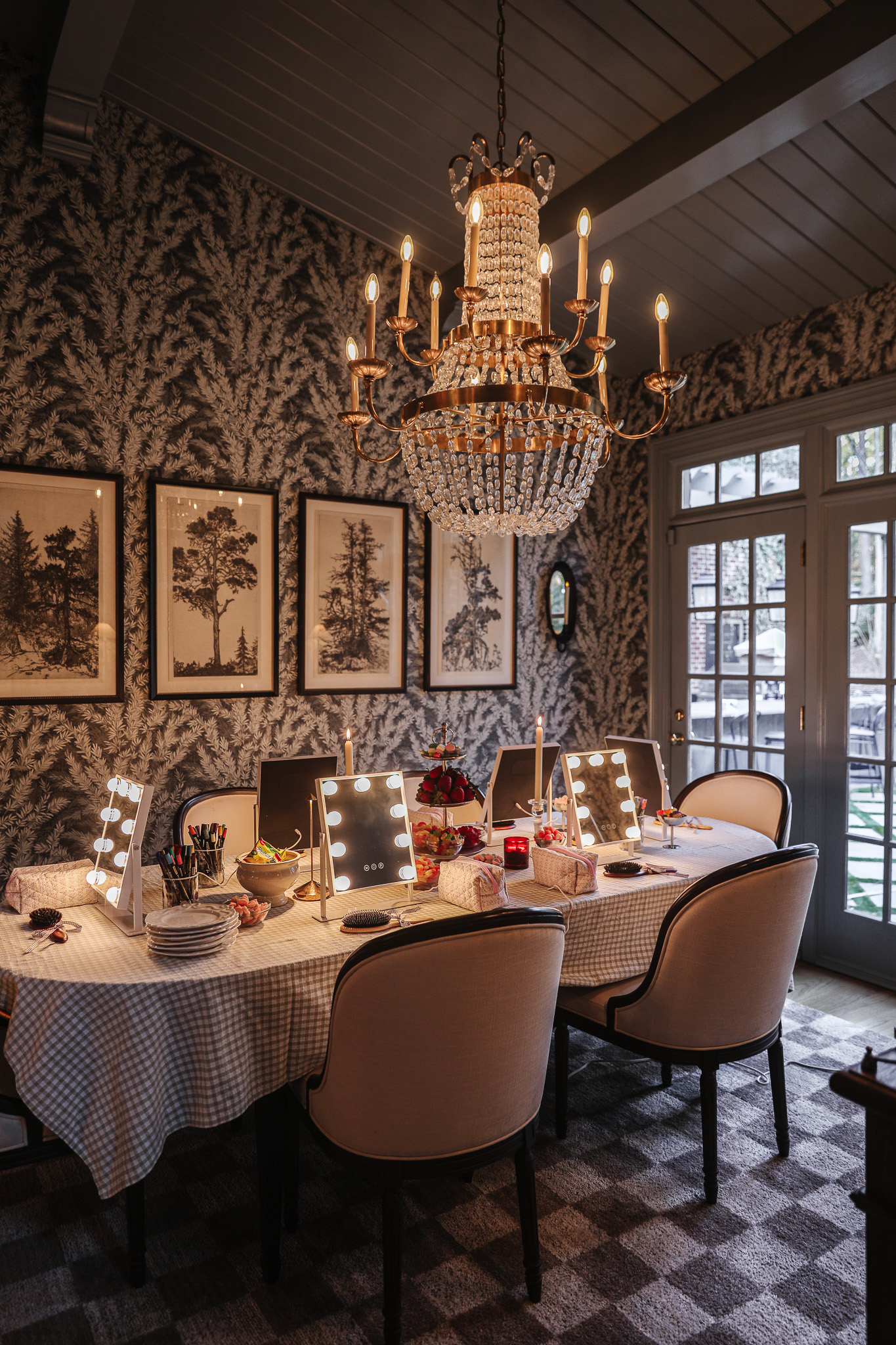 Charming dining room featuring a stunning chandelier, framed botanical prints, and a cozy, inviting atmosphere perfect for family dinners or intimate gatherings.