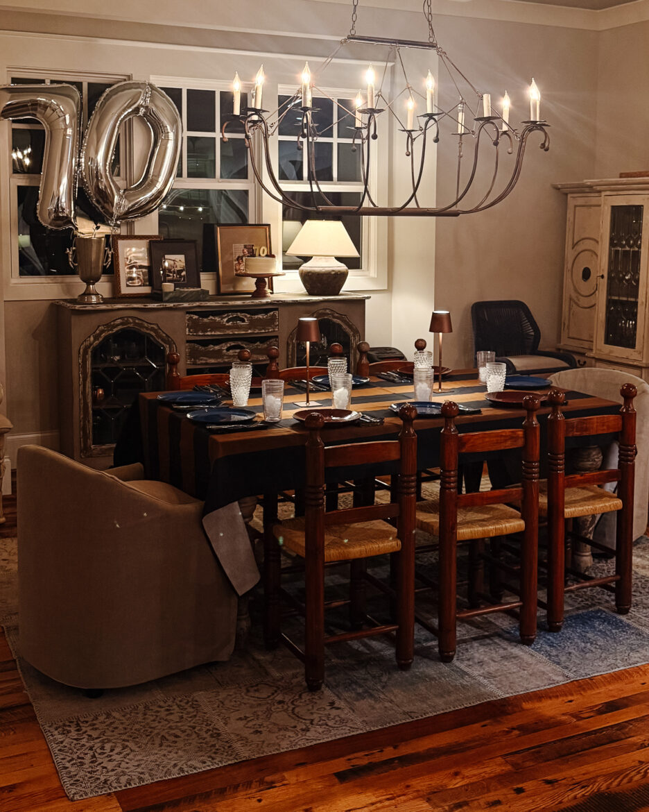 Warm and inviting dining room featuring a large wooden table, chandelier, and decorative accents for a stylish home interior.