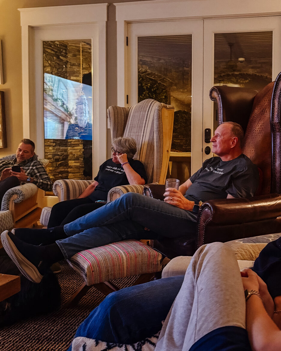 Relaxed family enjoying conversation and drinks in a cozy living room setting.