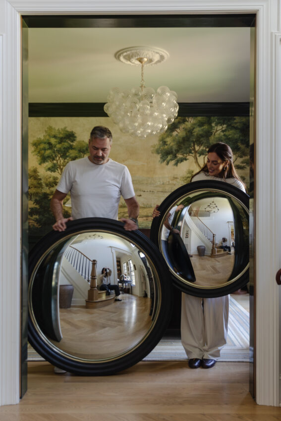 Chris and Julia Marcum holding Convex mirrors in front of their study