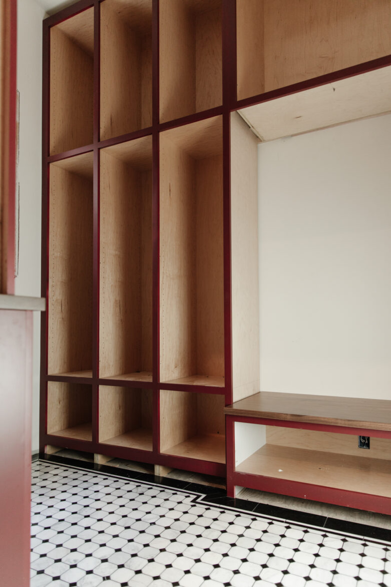Shelves being built in a mudroom while black & white tile creates a beautiful grounding element
