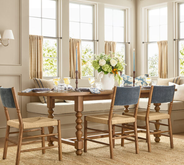 Modern, traditional blue and tan dining room with beautiful dining chairs with upholstered backs, a turned wood dining table, and wood candle holders