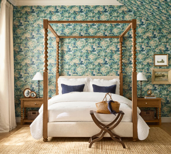 Beautiful bedroom setting with Chris Loves Julia warm wood nightstands, a canopy bed, vintage-style luggage rack , walnut table frames, and a brass clock
