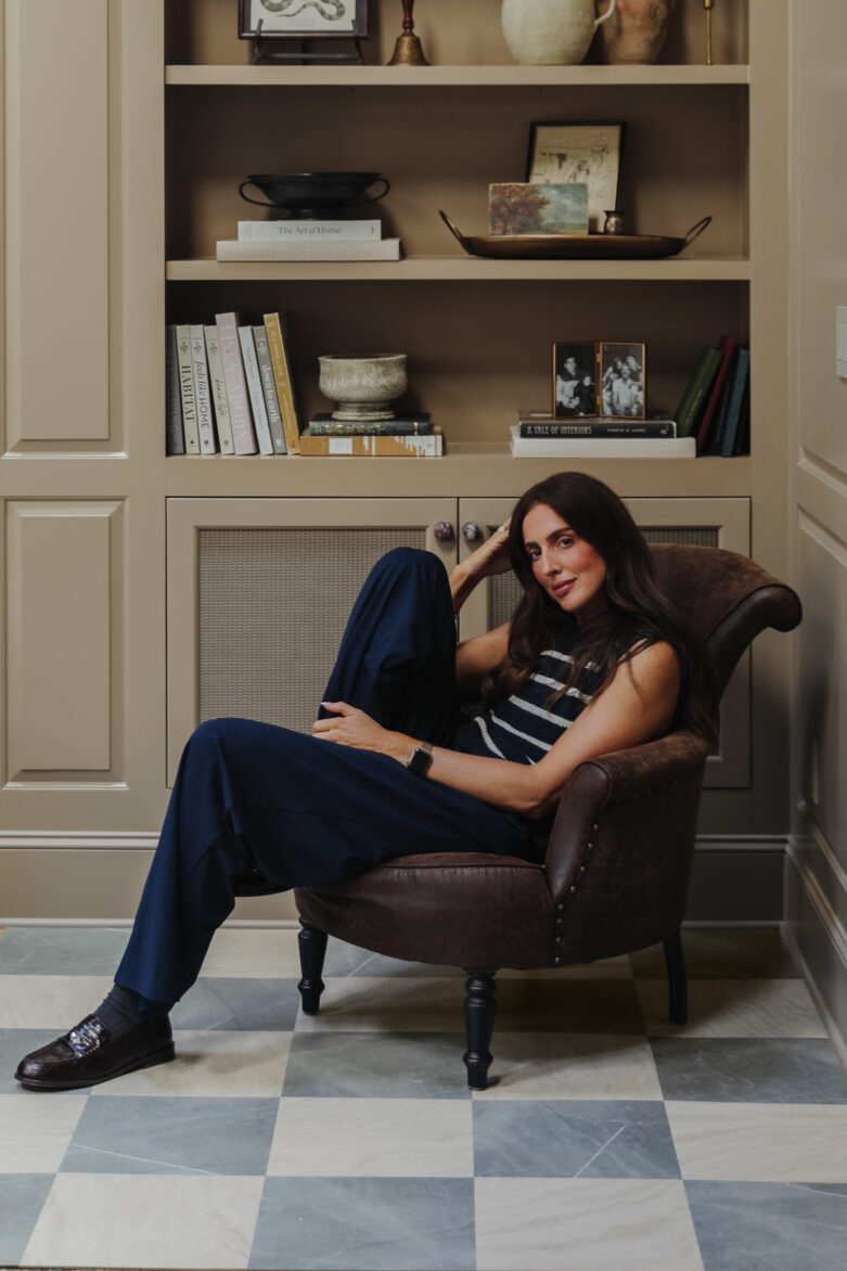 Slate & Beige Peel-and-Stick Tiles in a Living room with Julia sitting in front of a bookcase