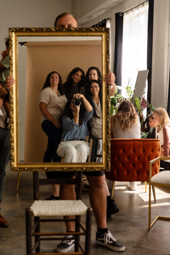 Group of women taking a selfie in a stylish, well-lit living room with modern decor, showcasing family and friends enjoying quality time together.