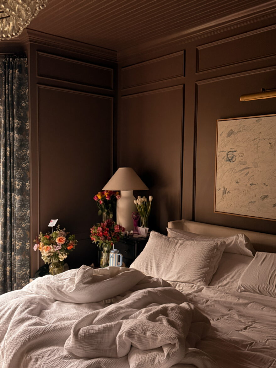 Marcum primary bedroom with flowers and unmade bed