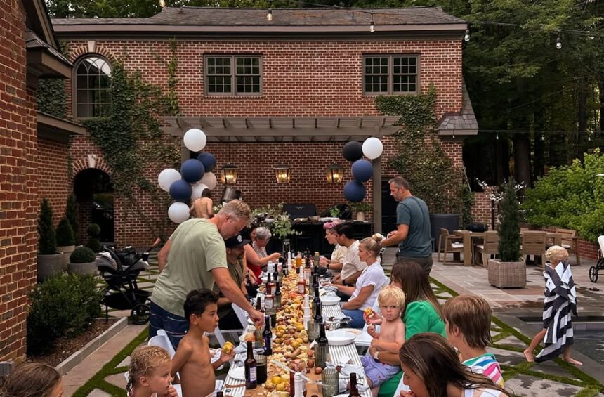 Outdoor dinner party with family and friends at a beautifully decorated backyard.