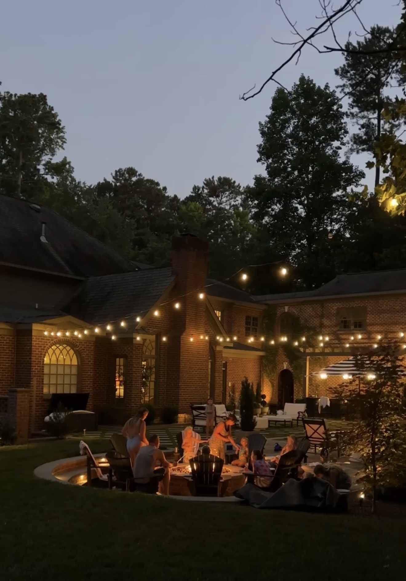 Outdoor evening gathering around a fire pit with friends and family.